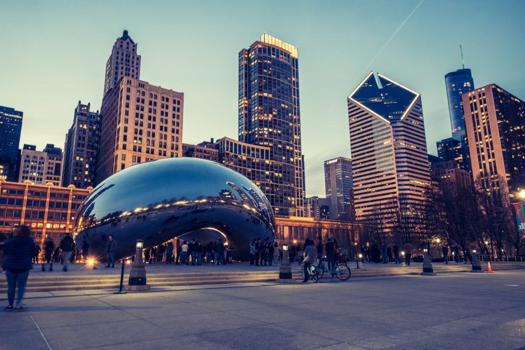 Photo of downtown Chicago at dusk with the Bean in the foreground and buildings in the background. Photo credit: unsplash
