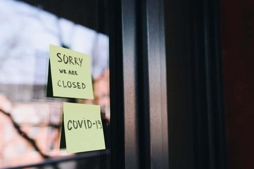 Photo of a business window with sticky notes reading "Sorry we are closed Covid-19" Photo credit: Anastasiia Chepinska via Unsplash